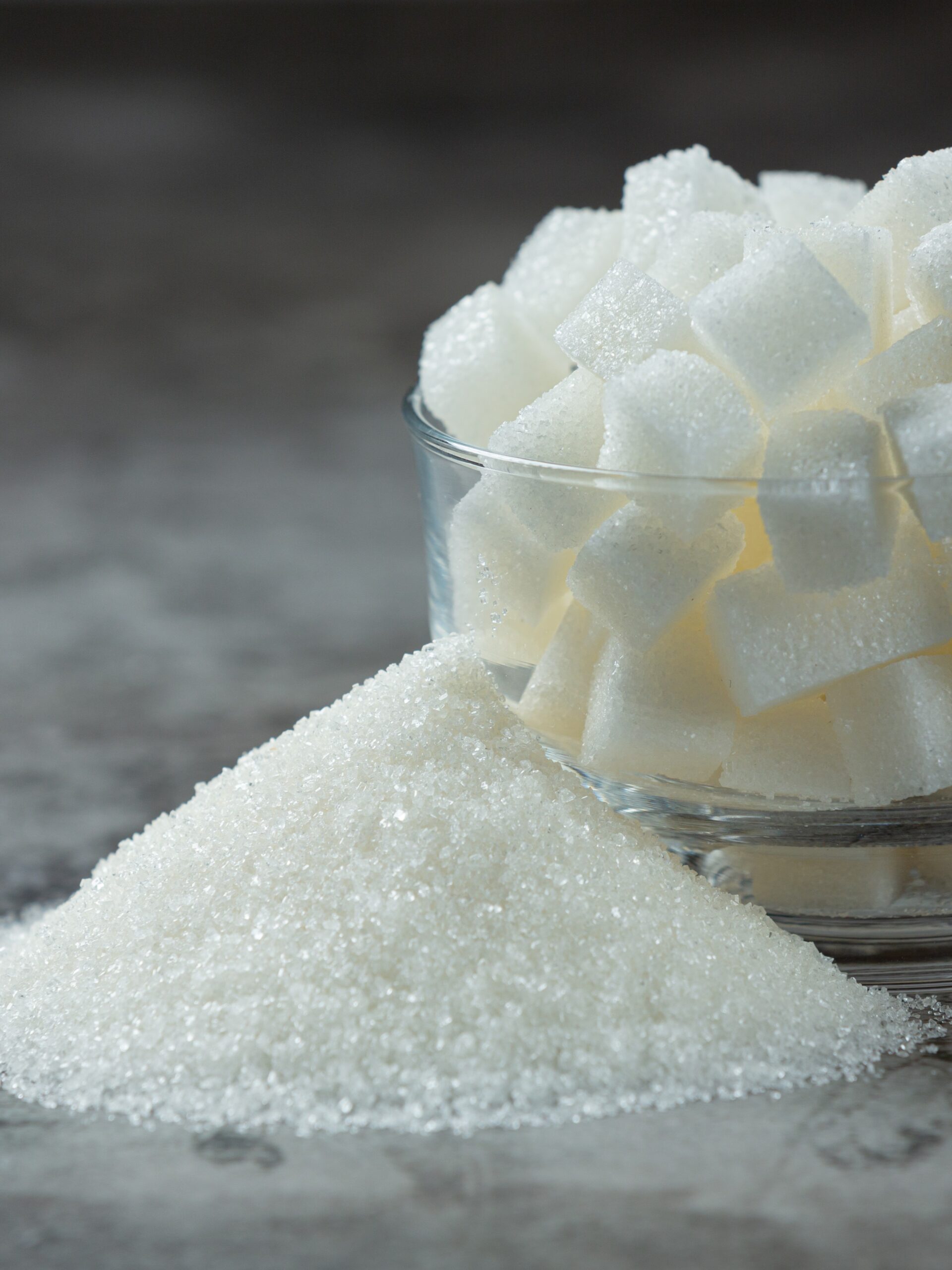 World diabetes day;Sugar cubes in a glass bowl on dark floor